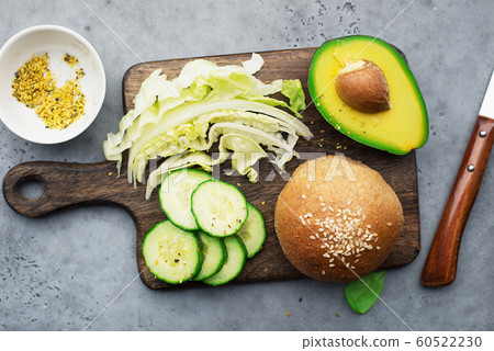 Healthy ingredients clean food. Avocado, whole grain bread, greens, lettuce, vegetables for a comfortable diet. Top view Healthy ingredients clean food. Avocado, whole grain bread, greens, lettuce, vegetables for a comfortable diet. Top view 60522230