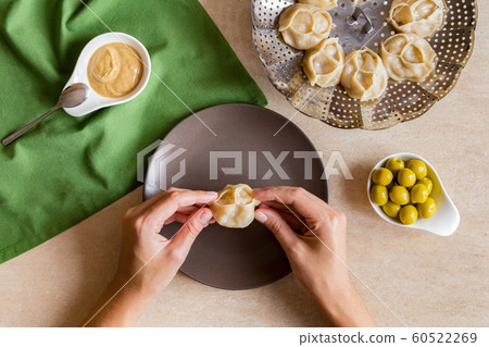Woman eat tasty Manti steam cooked meat dumplings Woman eat tasty Manti steam cooked meat dumplings 60522269