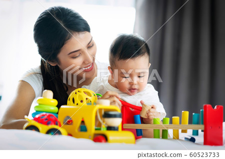 Asian mother and baby play togather with wooded Asian mother and baby play togather with wooded 60523733