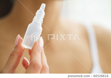 Vision And Medicine Concept. Young Girl Holds Eye Drops In Hands. Portrait of a Beautiful Woman with Contact Lenses. Healthy Look. High Resolution 60526618