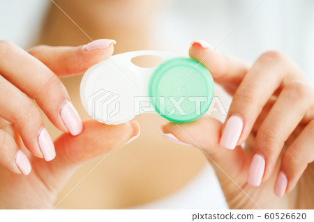 Vision And Medicine Concept. Young Girl Holds Eye Drops In Hands. Portrait of a Beautiful Woman with Contact Lenses. Healthy Look. High Resolution Vision And Medicine Concept. Young Girl Holds Eye Drops In Hands. Portrait of a Beautiful Woman with Contact Lenses. Healthy Look. High Resolution 60526620