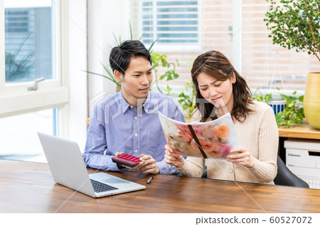  A couple staring at a household account book 60527072
