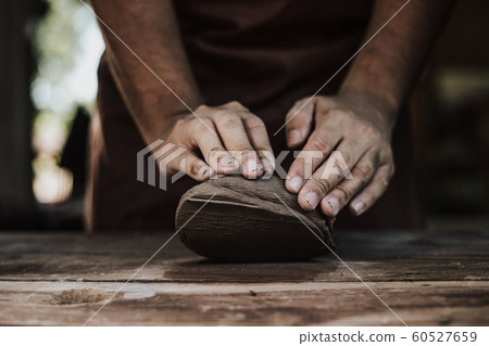 Craftsman hands close up, kneads and moistens the 60527659