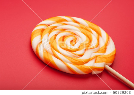 A large yellow Lollipop, on a scarlet background. A large yellow Lollipop, on a scarlet background. 60529208
