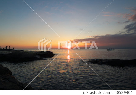 太陽即將下沉,它是美麗的。一艘船將要越過它。 太陽即將下沉,它是美麗的。一艘船將要越過它。 60529404