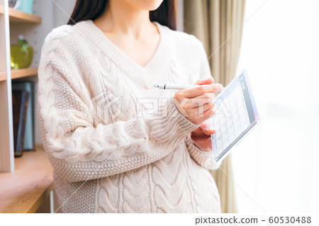 October Pregnant woman writing on calendar 60530488