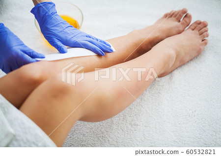 Waxing. Depilation legs with waxing and tape Waxing. Depilation legs with waxing and tape 60532821