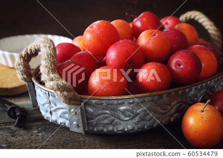 A lot of red plums in basket A lot of red plums in basket 60534479