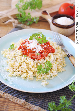 Pearl barley with tomato sauce and grated parmesan cheese Pearl barley with tomato sauce and grated parmesan cheese 60534696