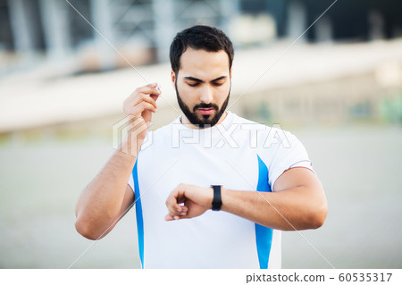 Sport man using headphones for listening music on morning run in park Sport man using headphones for listening music on morning run in park 60535317