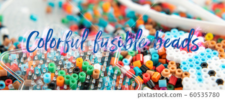 Colorful fusible beads or perler beads. Interesting toy for developing children's imagination, hand motility and learning colors. Hobby and leisure theme Colorful fusible beads or perler beads. Interesting toy for developing children's imagination, hand motility and learning colors. Hobby and leisure theme 60535780