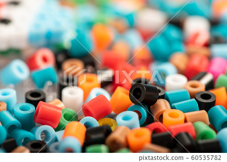 Set of colorful fusible beads close up. Known as perler beads. Toy that develops the imagination of child. Background with soft space for text. Children's toys theme Set of colorful fusible beads close up. Known as perler beads. Toy that develops the imagination of child. Background with soft space for text. Children's toys theme 60535782
