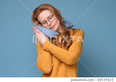 Mature adult woman with neck pillow resting and sleeping comfortable. Mature adult woman with neck pillow resting and sleeping comfortable. 60535923