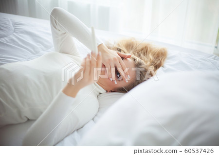 Positive pregnancy test. Young woman feeling depressed and sad after looking at pregnancy test result at home 60537426