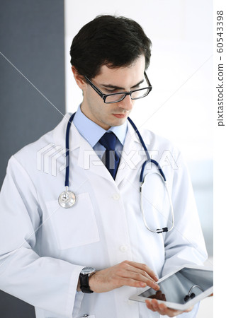 Doctor man using tablet computer for network research or virtual disease treatment. Perfect medical service in clinic. Modern medicine, medic data and healthcare concepts Doctor man using tablet computer for network research or virtual disease treatment. Perfect medical service in clinic. Modern medicine, medic data and healthcare concepts 60543398