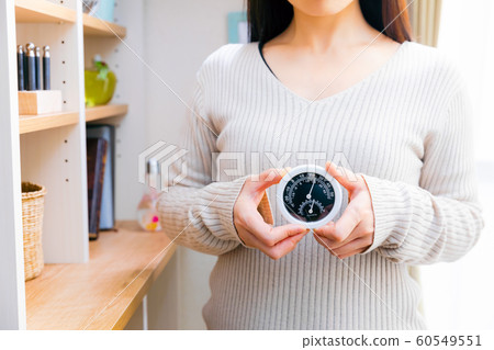 Woman with thermohygrometer 60549551