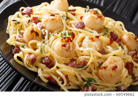 Spaghetti with seafood scallops and bacon in a Spaghetti with seafood scallops and bacon in a 60549662