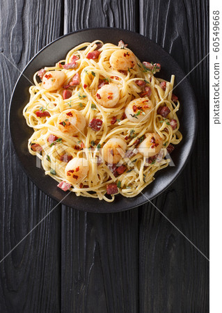 Spaghetti with seafood scallops and bacon in a Spaghetti with seafood scallops and bacon in a 60549668