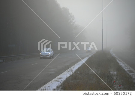 Cars in the fog. Bad winter weather and dangerous automobile traffic on the road. Vehicles in fog. 60550172