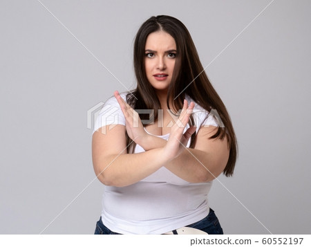 Plus Size Model with long hair gesturing no signal in studio. 60552197