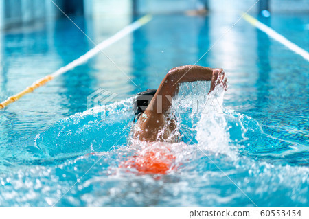 professional swimmer doing exercise in indoor swimming pool 60553454