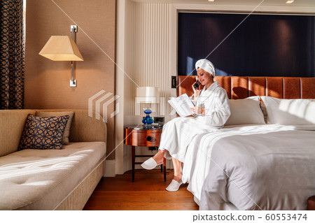 pretty young woman speak on the phone in her bed and read pretty young woman speak on the phone in her bed and read 60553474