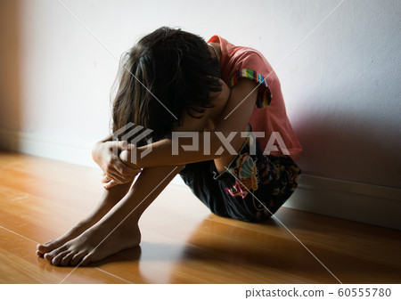 sad children,girl sitting alone in corner at home 60555780