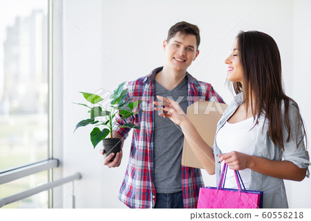 New Home. Funny young couple enjoy and celebrating moving to new home. Happy couple at empty room of new home 60558218