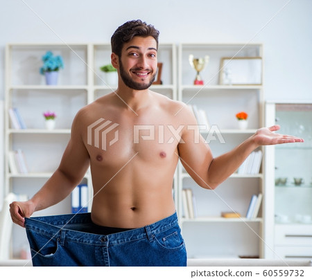 Man in oversized pants in weight loss concept 60559732