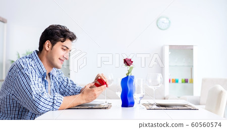 Man alone preparing for romantic date with his sweetheart Man alone preparing for romantic date with his sweetheart 60560574