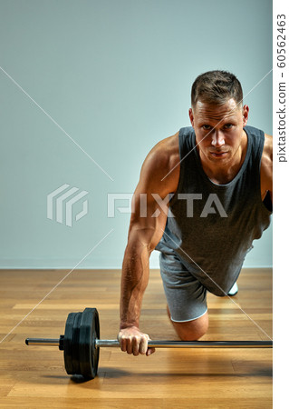 Man doing back workout, barbell row in studio over gray background. Copy space 60562463