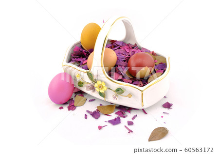 Handmade easter eggs in a basket with wooden decoration Handmade easter eggs in a basket with wooden decoration 60563172