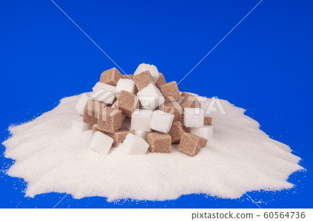 Heap of cane sugar and white sugar on a blue background Heap of cane sugar and white sugar on a blue background 60564736