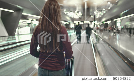 woman with luggage stand on speedwalk at airport woman with luggage stand on speedwalk at airport 60564832