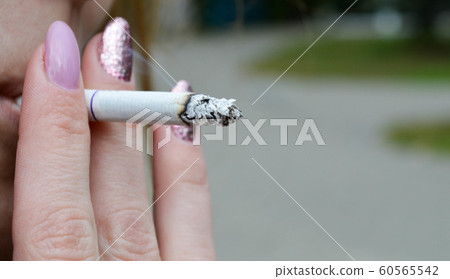 girl with a purple manicure tightens a cigarette girl with a purple manicure tightens a cigarette 60565542