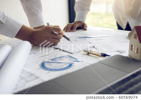 Engineering man showing blueprint detail for 60569074