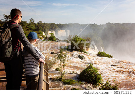 family enjoying iguazu falls 60571132