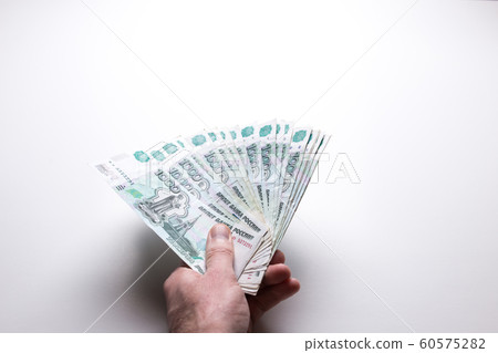 Male hand holds Russian rubles on a white isolated background. Male hand holds Russian rubles on a white isolated background. 60575282