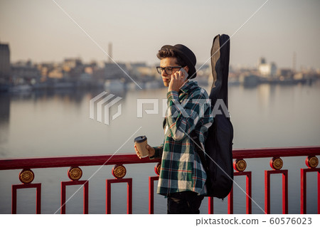 Musician in hat stand with mobile phone and coffee Musician in hat stand with mobile phone and coffee 60576023