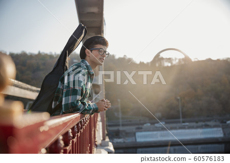 Smiling musician in hat standing on bridge Smiling musician in hat standing on bridge 60576183
