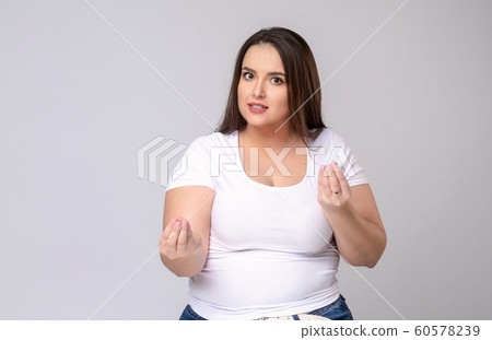 Plus Size Model with long hair meditates in studio. 60578239