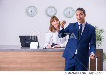 Young businessman at hotel reception 60578770