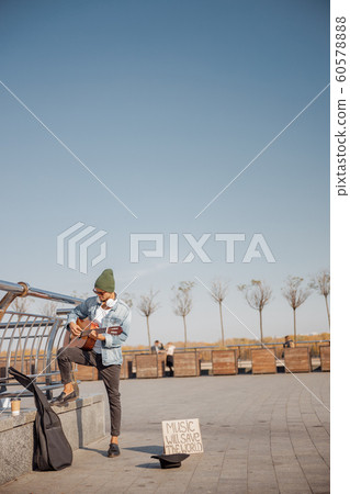 Guitarist in hat playing guitar on the street Guitarist in hat playing guitar on the street 60578888