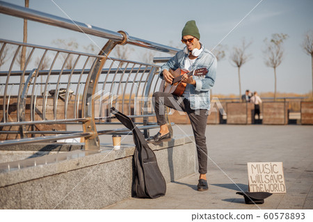 Stylish guy with guitar standing in the city 60578893