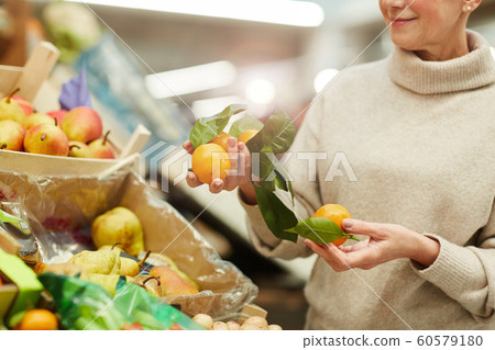 Woman Choosing Fruits at Farmers Market Woman Choosing Fruits at Farmers Market 60579180