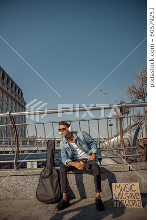 Young guy wearing headphones on the street Young guy wearing headphones on the street 60579251