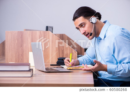 Call center operator working at his desk 60580268
