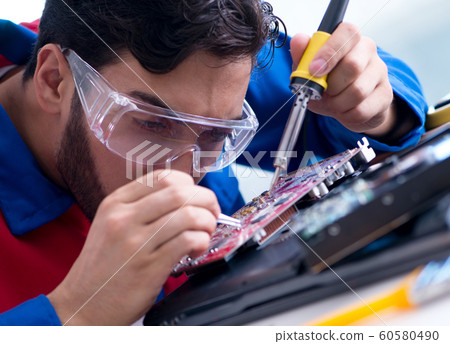 Repairman working in technical support fixing computer laptop tr 60580490
