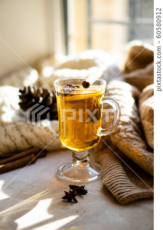 Hot winter drink with cinnamon and lemon on bright sunny day 60580912