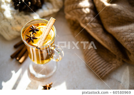 Hot winter drink with cinnamon and lemon on bright sunny day 60580969